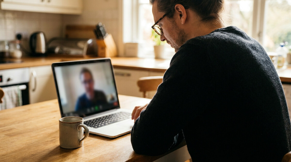 Freelancer on video call with a first freelance client at kitchen table